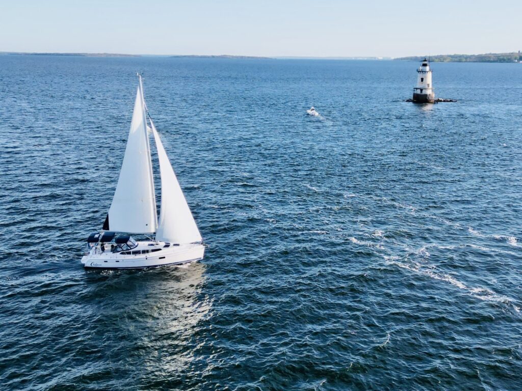 Chillaxin yacht on the water with a lighthouse in the background