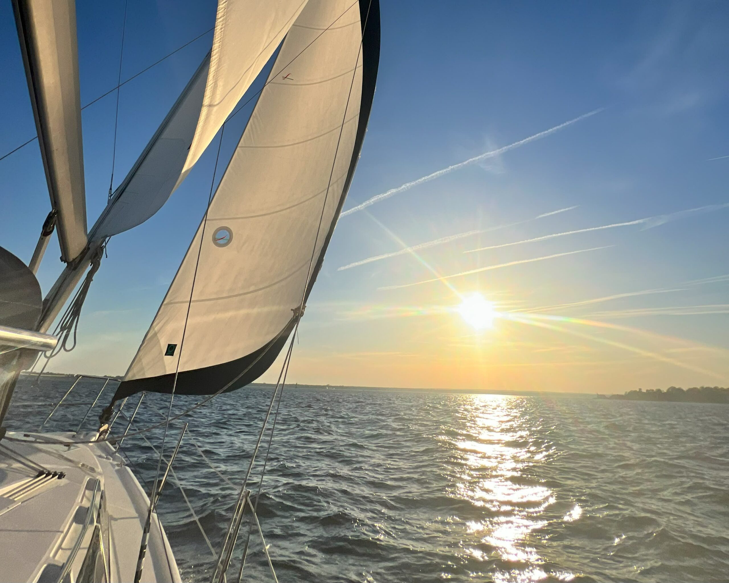 Chillaxin yacht on the water with the sun in the background